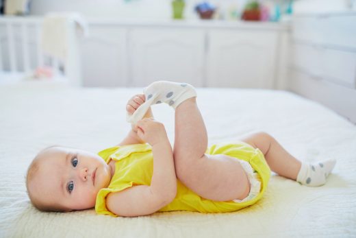 Adorable petite fille retire son pied de d'une chaussette