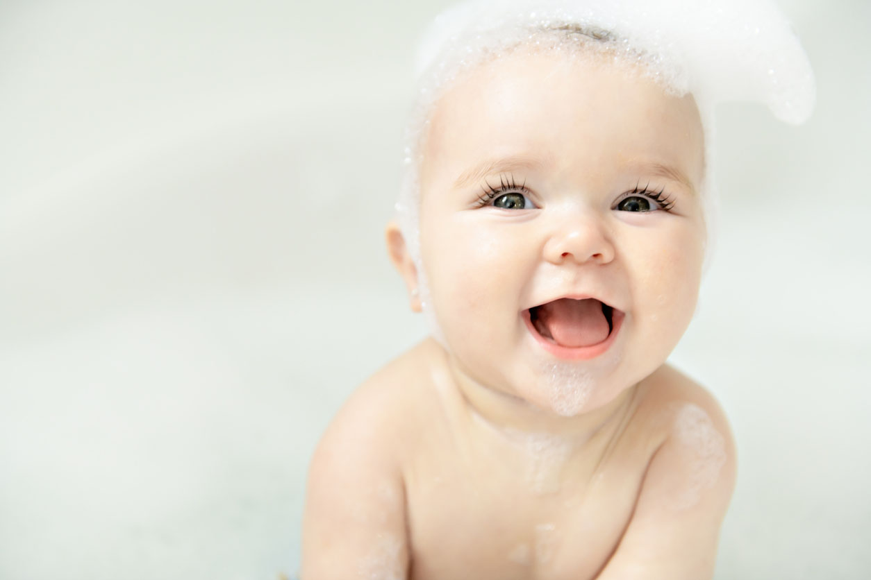 un bébé baigne dans un bain avec de la mousse et des bulles de savon