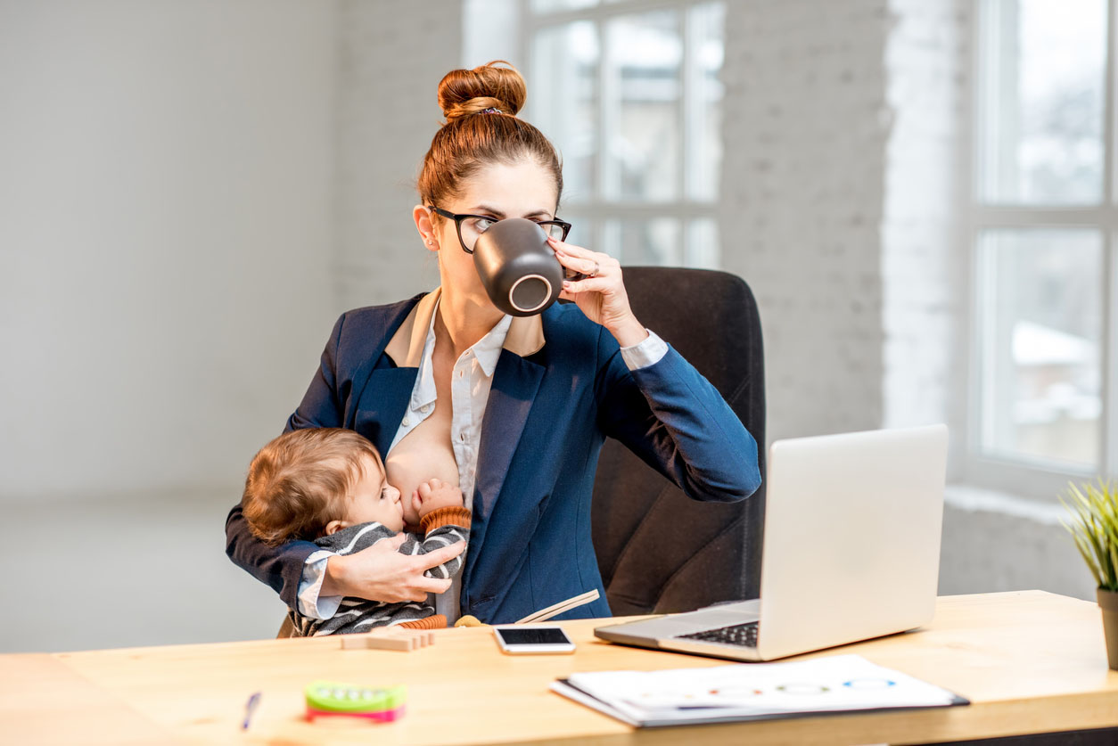 Femme d’affaires travaillant au bureau donnant le sein à son bébé