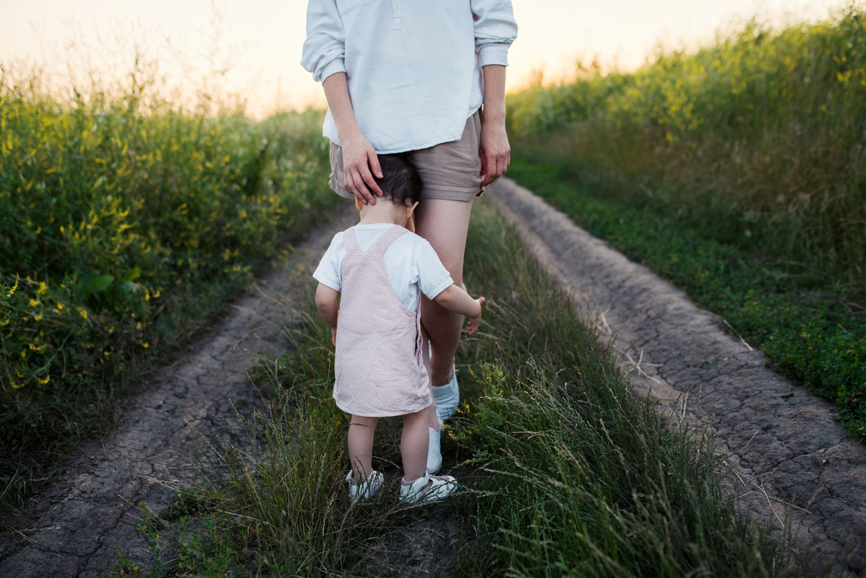 enfant qui pleure dans les jambes de sa maman