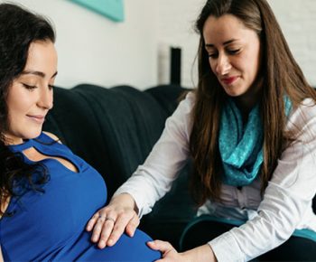 femme qui touche le ventre enceinte de son amie