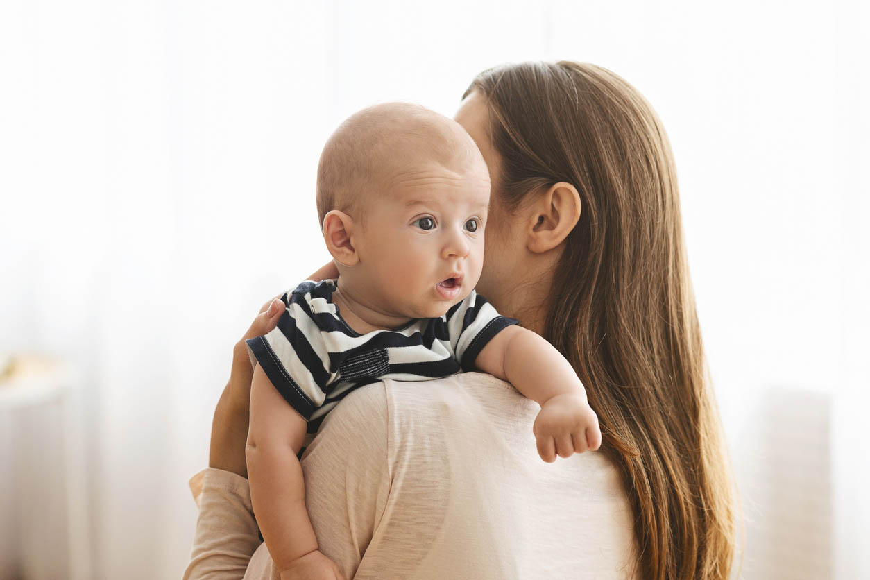 Mère tapotant le bébé sur le dos pour qu'il fasse son rot