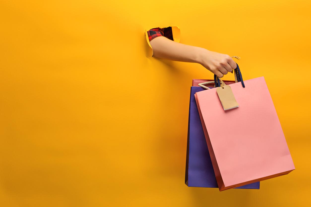 Female Hand Holding Bright Shopping Bags