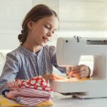 Petite Fille Qui Utilise Une Machine à Coudre