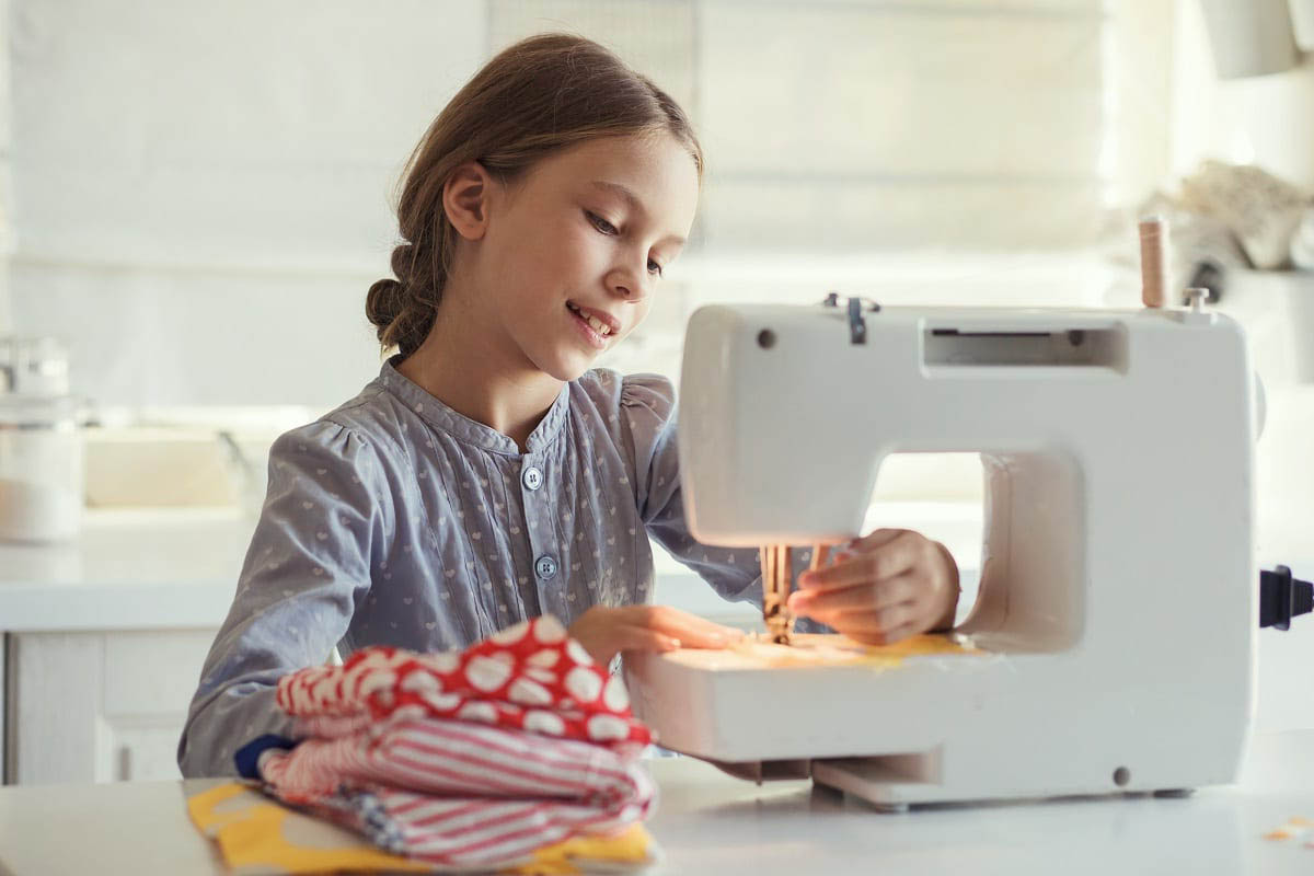 Petite Fille Qui Utilise Une Machine à Coudre