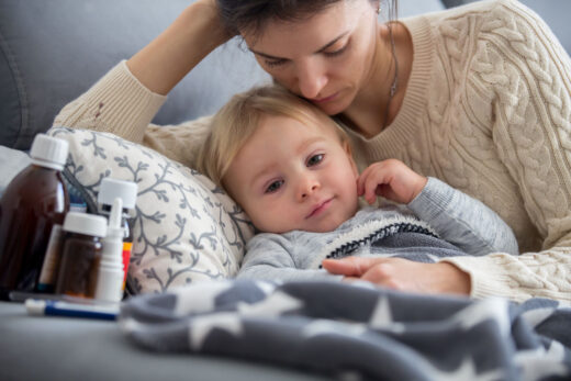 Sick Child, Toddler Boy Lying In Bed With A Fever, Resting At Home