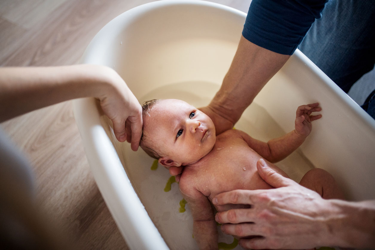 Parents donnant un bain a bébé 