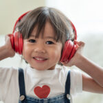 enfant asiatique heureux apprécient écouter la musique avec des écouteurs