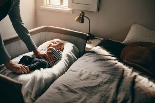 Jeune maman en regardant son bébé dormir dans un lit de bébé