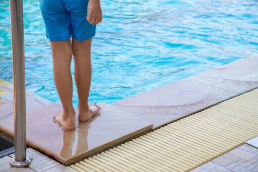 Nageur enfant debout côté piscine