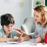 Enfant avec des difficultés se fait aider par un adulte