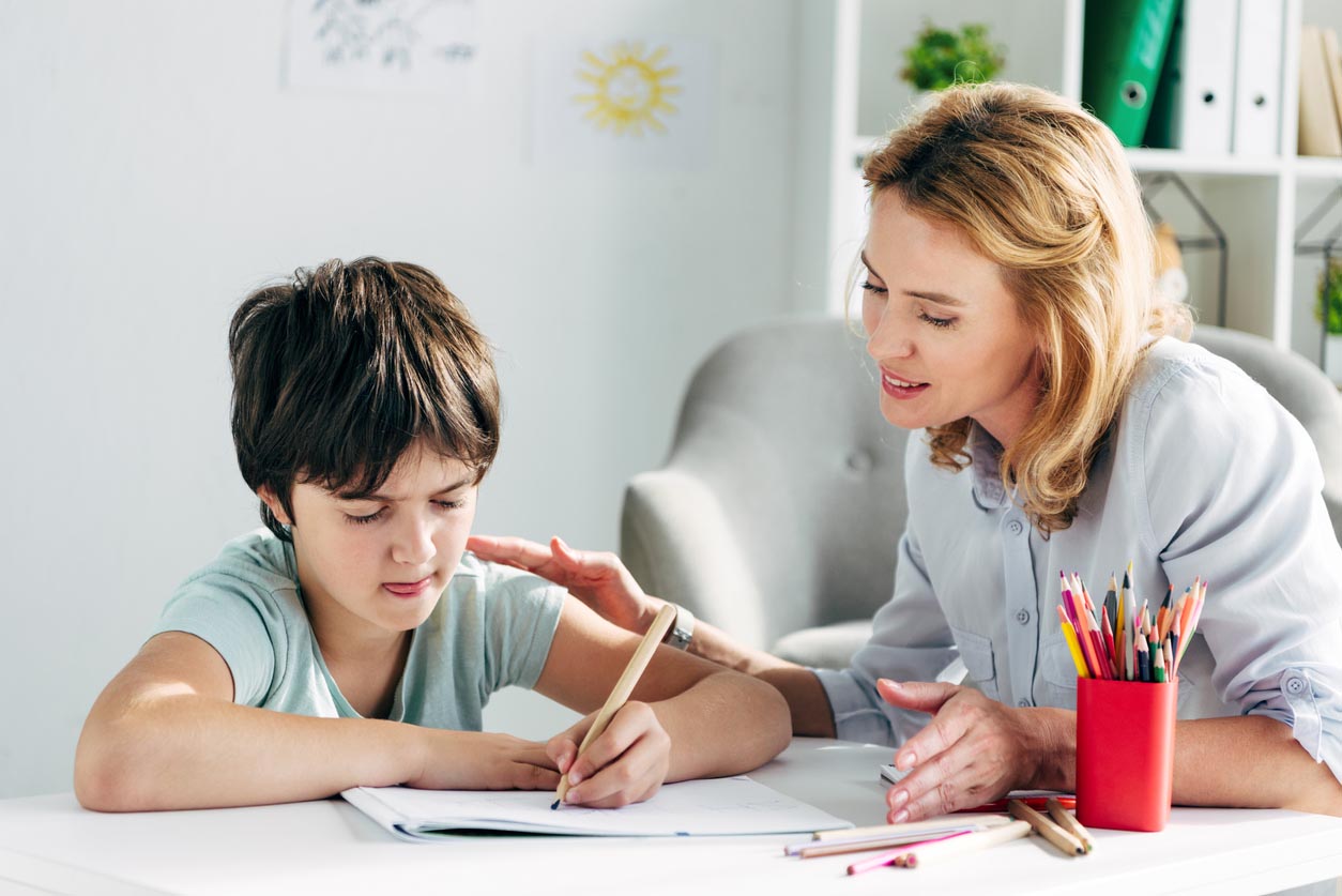 Enfant avec des difficultés se fait aider par un adulte