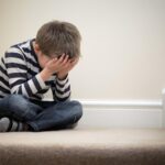 Contrarié problème enfant assis sur l'escalier
