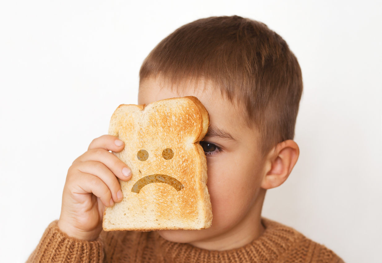 Children And Gluten. Preschool Boy With Toasted Bread, With Sad Emoji. Gluten Intolerance By Kids.