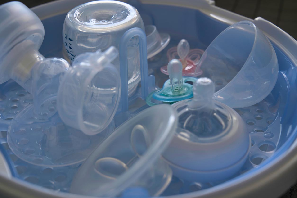 Biberons de bébé dans un bac de stérilisation