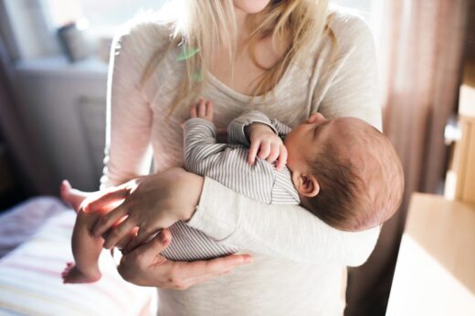 Jeune mère tiens son bébé endormi dans ses bras