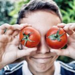 Adolezcent Avec Des Tomates Devant Les Yeux