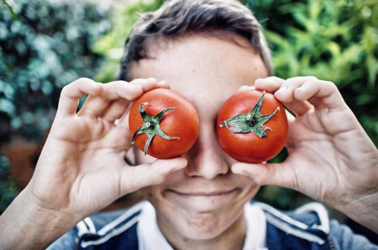 Adolezcent Avec Des Tomates Devant Les Yeux