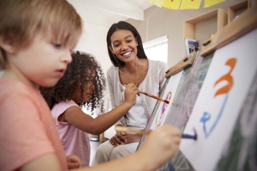 La maitresse regarde le travail des enfants à la peinture