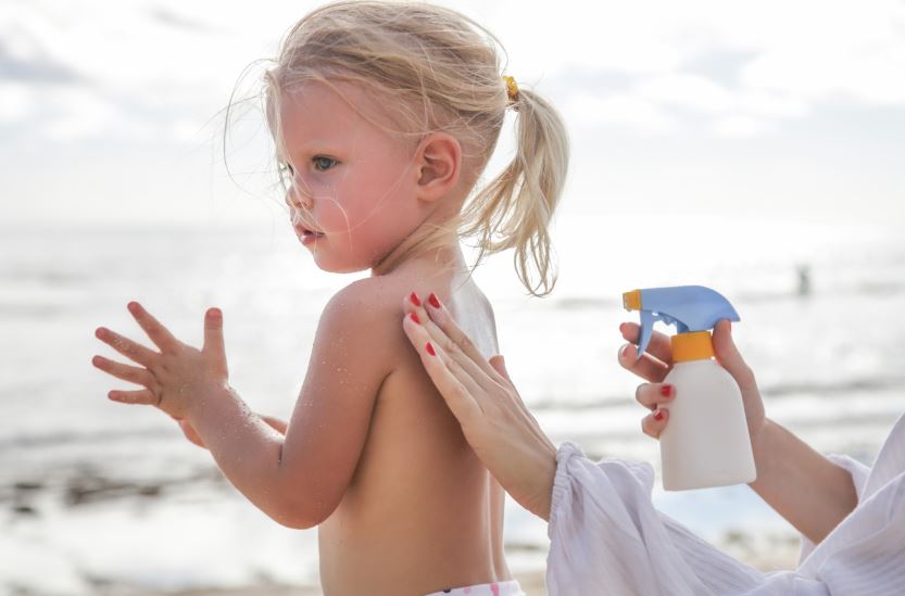 Mère Appliquant La Lotion De Protection Sur La Petite Fille