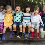 Les enfants de maternelle s’entment assis en souriant