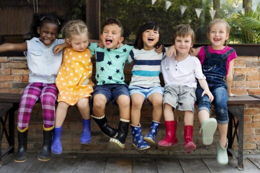 Les enfants de maternelle s’entment assis en souriant