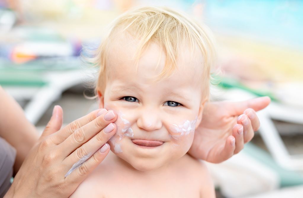 Maman Applique De La Crème Sur Le Visage De Bébé